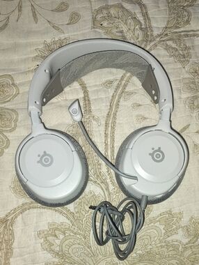white SteelSeries Arctis Nova 1P wired gaming headphones. [1]